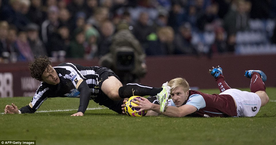 Newcastle United's Dutch defender Daryl Janmaat (left) and Burnley's Ben Mee get into a tangle on the deck