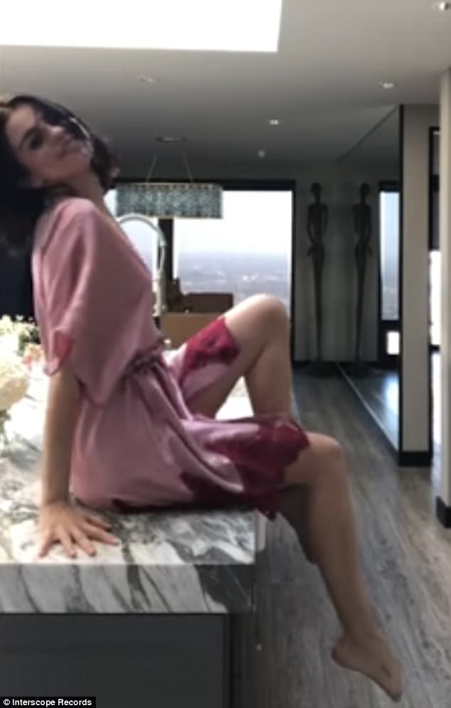 Showing off: The 25-year-old hitmaker could be seen with wet hair and a pink robe as she gallivants around her home throughout the video