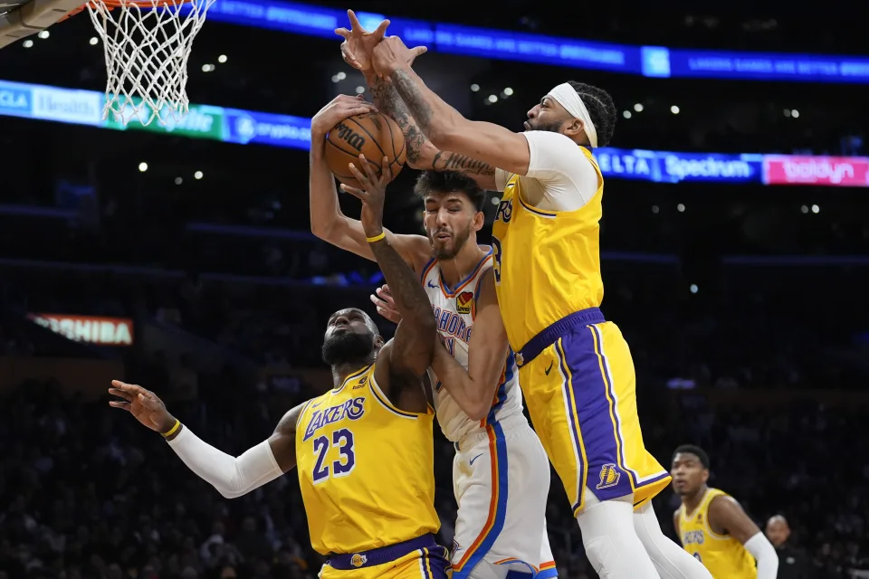 Oklahoma City Thunder forward Chet Holmgren, center, works for a rebound between Los Angeles Lakers forward LeBron James (23) and forward Anthony Davis during the first half of an NBA basketball game, Monday, March 4, 2024, in Los Angeles. (AP Photo/Marcio Jose Sanchez)