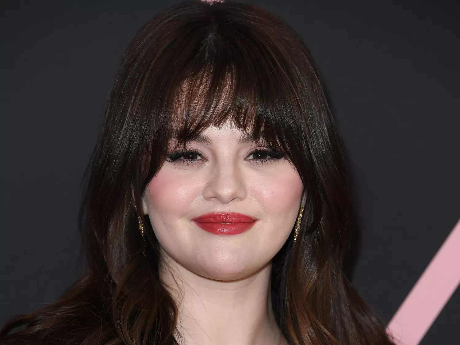 Selena Gomez wearing red lipstick and bangs