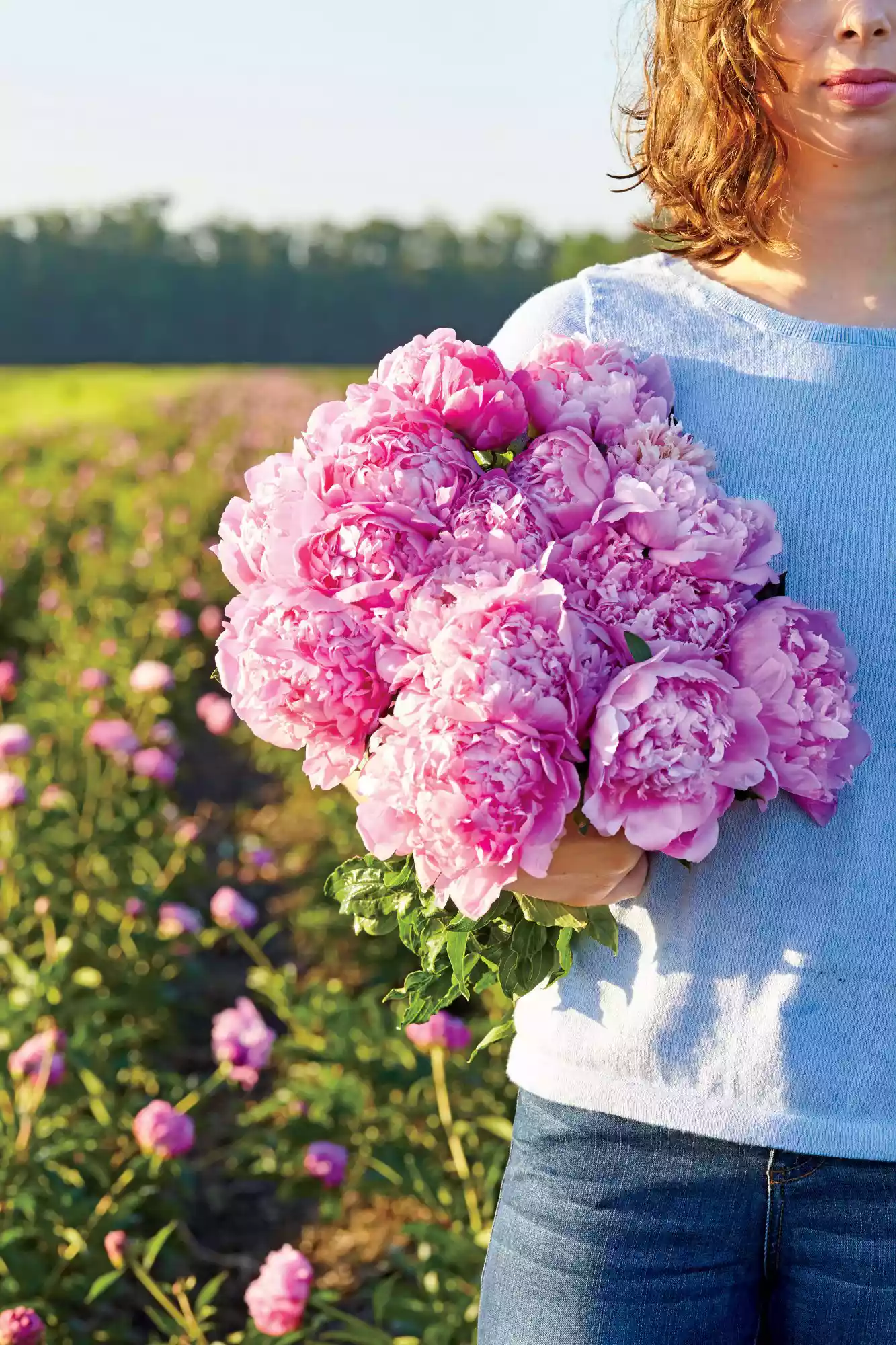 Girl Holding Peonies in Field