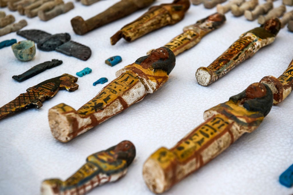 Carved wooden statues and funerary figurines called "Ushabtis," made of wood, faience and clay discovered by an Egyptian archaeological mission at the site of Tomb TT28, or Thaw-Irkhet-If, at Al-Assasif necropolis on the west bank of the Nile north of the southern Egyptian city of Luxor. Photo by Khaled Desouki/AFP/Getty Images.