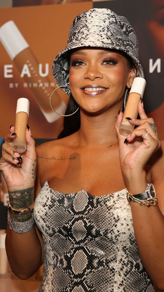 Rihanna holding her Fenty Beauty foundation.
