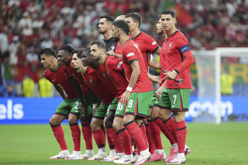 Portugal starting players pose for a team photo at the beginning of a round of sixteen match between Portugal and Slovenia at the Euro 2024 soccer tournament in Frankfurt, Germany, Monday, July 1, 2024. (AP Photo/Ebrahim Noroozi)