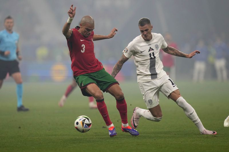 Portugal's Pepe, left, and Slovenia's Benjamin Sesko vie for the ball during a round of sixteen match between Portugal and Slovenia at the Euro 2024 soccer tournament in Frankfurt, Germany, Monday, July 1, 2024. (AP Photo/Ariel Schalit)